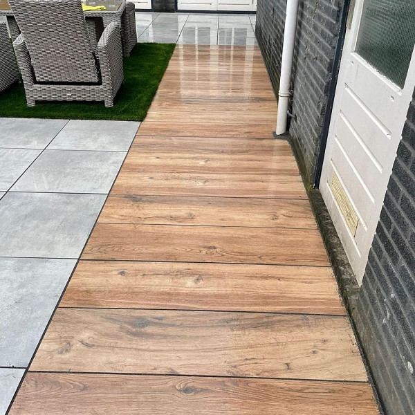 <p><strong>GeoCeramica Mensola</strong></p><p>Deze fraaie houtlook laat zich bijzonder goed complimenteren met diens omgeving. De combinatie met struiken, groene borders en planten is bijzonder mooi. Juist een contrastmuur of vlak steekt ook heel mooi af. Een veelzijdige alleskunner die een bijzonder fraai resultaat gaat geven voor je buitenruimte.</p><p><strong>Welkom bij Sierbestrating Jonk - Dé Specialist in Keramische Tegels met Houtlook voor Buiten</strong></p><p>Ontdek de perfecte combinatie van natuurlijke schoonheid en duurzaamheid met onze exclusieve collectie keramische tegels voor tuin en terras. Bij Sierbestrating Jonk geloven we dat buitenruimtes niet alleen functioneel moeten zijn, maar ook een verlengstuk van uw persoonlijke stijl en levensstijl. Onze keramische tegels met houtlook zijn de ideale keuze voor wie de warmte van hout wil combineren met de voordelen van duurzaam keramiek.</p><p><strong>Waarom Kiezen voor Keramische Tegels met Houtlook?</strong></p><p><em>1. Duurzaamheid:</em> Onze keramische tegels zijn bestand tegen alle weersomstandigheden, vervagen niet in de zon en zijn slijtvast. Ze behouden hun schoonheid door de seizoenen heen.</p><p><em>2. Onderhoudsvriendelijk:</em> Vergeet het constante onderhoud dat bij echt hout hoort. Onze tegels vereisen minimaal onderhoud en behouden hun oorspronkelijke uitstraling zonder dat u zich zorgen hoeft te maken over schuren of oliën.</p><p><em>3. Natuurlijke Uitstraling:</em> Dankzij geavanceerde technologie repliceren onze keramische tegels de warme en authentieke uitstraling van echt hout tot in de kleinste details. Geniet van de natuurlijke schoonheid zonder concessies te doen aan prestaties.</p><p><strong>Ontdek Onze Collectie:</strong></p><p><em>1. Houtsoorten:</em> Van klassiek eiken tot exotisch larixhout, onze collectie biedt een scala aan houtsoorten om aan verschillende smaken en stijlen te voldoen.</p><p><em>2. Afmetingen en Vormen:</em> Kies uit diverse formaten en vormen om een uniek patroon te creëren dat perfect aansluit bij uw buitenruimte.</p><p><em>3. Accessoires:</em> Maak uw buitenruimte compleet met bijpassende accessoires, zoals traptreden en afwerkranden, voor een naadloze integratie van uw nieuwe vloer.</p><p>Bij Sierbestrating Jonk streven we ernaar om uw buitenleven te verrijken met hoogwaardige keramische tegels met houtlook. Ontdek de eindeloze mogelijkheden voor het transformeren van uw tuin en terras.</p><p><strong>Ontdek de Revolutie in Tuintegels: Geoceramica - Waar Functionaliteit Samenkomt met Esthetiek</strong></p><p>Bij Sierbestrating Jonk introduceren we met trots Geoceramica, een innovatieve revolutie in tuintegels die de perfecte balans vindt tussen functionaliteit en esthetiek. Deze geavanceerde keramische tegels zijn ontworpen om aan al je verwachtingen te voldoen en je buitenruimte te transformeren tot een oase van schoonheid en duurzaamheid.</p><p><em>Waarom kiezen voor Geoceramica?</em></p><p><strong>1.</strong> <strong>Dual Power:</strong> Geoceramica combineert de voordelen van keramiek en beton in één unieke tegel. Het keramische oppervlak biedt een luxe uitstraling en is tegelijkertijd bestand tegen krassen, vlekken en verkleuring. Het betonnen draagsysteem zorgt voor de benodigde stabiliteit en duurzaamheid.</p><p><strong>2. Extreme Weerbestendigheid:</strong> Dankzij de geavanceerde productietechnieken zijn Geoceramica tegels bestand tegen extreme weersomstandigheden. Vorst, hitte of regen, deze tegels blijven hun schoonheid behouden, jaar na jaar.</p><p><strong>3. Eenvoudige Installatie:</strong> Het unieke ontwerp van Geoceramica maakt snelle en eenvoudige installatie mogelijk. Of je nu een ervaren klusser bent of professionele hulp zoekt, de tegels zijn ontworpen voor een efficiënte plaatsing.</p><p><strong>4. Milieuvriendelijk:</strong> Geoceramica is gemaakt met oog voor het milieu. Het gebruik van duurzame materialen en de lange levensduur van de tegels dragen bij aan een groenere leefomgeving.</p><p><strong>5. Ruime Designkeuze:</strong> Of je nu houdt van strakke lijnen, rustieke texturen of moderne patronen, Geoceramica biedt een breed scala aan designs en kleuren. Personaliseer je buitenruimte naar jouw smaak en creëer een unieke ambiance.</p><p>Upgrade je terras, tuinpad of binnenplaats met de veelzijdige en duurzame Geoceramica tegels van Sierbestrating Jonk. Ontdek de perfecte combinatie van stijl en kracht voor een buitenruimte die de tand des tijds doorstaat.</p><p>Neem contact met ons op voor meer informatie of om onze collectie Geoceramica tegels te bekijken. Maak van je buitenruimte een meesterwerk met Geoceramica!</p>