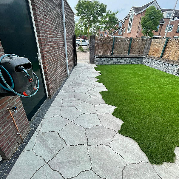 <h1><strong>GeoArdesia Alivo</strong></h1><p>Een terras maken met het uiterlijk van natuursteen flagstones is kinderspel geworden met de GeoArdesia Alivo. Het innovatieve design laat je bestrating enorm gevarieerd lijken, maar is door zijn unieke vorm met gemak te leggen. De tegel bestaat slechts uit één vorm. Een echte aanrader voor de klassieke en romantische tuin.<br /><br />De natuurlijke uitstraling van deze serie wordt verkregen door een buitengewoon oppervlaktestructuur, dat sterk aan leisteen doet denken. Bovendien is de steen voorzien van Footcomfort® waardoor deze buitengewoon comfortabel is voor grote en kleine blote voeten!</p><h2><strong>Kristaleffect</strong></h2><p>Door toevoeging van een speciaal glinsterzand in het oppervlak ontstaat een karakteristiek ogend, licht veredeld kristaleffect. Door het subtiele gebruik van deze speciale, glinsterende deeltjes hebben de tegels een buitengewone en niet te evenaren charme.</p><h2><strong>Leisteenreliëf</strong></h2><p>‘Ardesia’ is italiaans voor ‘leisteen’. De fijn gestructureerde oppervlakte bevat een zeer licht golvend, variërend profiel, gelijkend aan een echte leisteen, hetgeen in het bijzonder naar voren komt bij zonweerspiegeling. Het leisteenreliëf is zo nauwkeurig nagebootst dat het nauwelijks te onderscheiden is als dat van echte leisteen flagstones.</p><h2><strong>Onderhoudsvriendelijk</strong></h2><p>De kwaliteitstegels zijn met een exclusieve, transparante bescherming afgewerkt. Deze Protection Plus factor 25 beschermt de tegels tegen vervuiling en verontreiniging. Tijdens productie van de tegels wordt er een transparante dubbele beschermlaag aangebracht, zodat de poriën van de toplaag praktisch gesloten worden. Dit gebeurt direct na productie. Vervuiling hou je in weer en wind natuurlijk nooit tegen. Protection plus factor 25 maakt dat het schoonmaken een stuk minder vervelend en tijdrovend wordt. Vlekken zijn gemakkelijker te verwijderen omdat vloeistoffen op het oppervlak blijven staan en niet in de steen dringen. Als een schild houdt de behandelde tegel diverse vloeistoffen tegen. Belangrijk: organisch vuil (bijvoorbeeld bladeren en vogelpoep) op de tegels dien je frequent te verwijderen. Zelfs al is de tegel zo goed beschermd, er zal vlekvorming ontstaan als je niet met regelmaat organisch vuil van de tegels verwijderd.</p><h2><strong>Geosteen®</strong></h2><p>Geosteen staat voor sierbestrating met een hoogwaardige toplaag. Aan de basis staat een oersterke betonnen ondertegel van gerecyclede materialen. Hier wordt een toplaag in geperst van hoogwaardige natuurlijke granulaten. Dit draagt ertoe bij dat, ten opzichte van bijvoorbeeld betontegels die op kleur zijn gemaakt d.m.v. kleurstoffen, de tegels over langere termijn mooi blijven. Dit uit zich in betere kleurechtheid, betere slijtvastheid, een natuurlijke uitstraling en betere duurzaamheid.</p><h2><strong>Voegen</strong></h2><p>De voegen tussen de GeoAlivo zijn groter dan bij andere GeoSteen, waardoor standaard al WS voegmortel toegepast kan worden. Het verbruik is circa 3,2 kg per m2.</p>