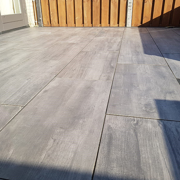 <h1><strong>GeoCeramica Timber</strong></h1><p>Hout is een levend, sfeervol materiaal met onvoorspelbare knoesten en patronen. De Esthetiek is tijdloos en floreert tot op de dag van vandaag. Vandaag misschien wel meer dan ooit. Het is robuust, natuurlijk én stijlvol. Kies ook voor de schoonheid van hout maar dan wel met de beste keramische eigenschappen die er zijn.</p><h2><strong>Welkom bij Sierbestrating Jonk - Dé Specialist in Keramische Tegels met Houtlook voor Buiten</strong></h2><p>Ontdek de perfecte combinatie van natuurlijke schoonheid en duurzaamheid met onze exclusieve collectie keramische tegels voor tuin en terras. Bij Sierbestrating Jonk geloven we dat buitenruimtes niet alleen functioneel moeten zijn, maar ook een verlengstuk van uw persoonlijke stijl en levensstijl. Onze keramische tegels met houtlook zijn de ideale keuze voor wie de warmte van hout wil combineren met de voordelen van duurzaam keramiek.</p><p><strong>Waarom Kiezen voor Keramische Tegels met Houtlook?</strong></p><p><em>1. Duurzaamheid:</em> Onze keramische tegels zijn bestand tegen alle weersomstandigheden, vervagen niet in de zon en zijn slijtvast. Ze behouden hun schoonheid door de seizoenen heen.</p><p><em>2. Onderhoudsvriendelijk:</em> Vergeet het constante onderhoud dat bij echt hout hoort. Onze tegels vereisen minimaal onderhoud en behouden hun oorspronkelijke uitstraling zonder dat u zich zorgen hoeft te maken over schuren of oliën.</p><p><em>3. Natuurlijke Uitstraling:</em> Dankzij geavanceerde technologie repliceren onze keramische tegels de warme en authentieke uitstraling van echt hout tot in de kleinste details. Geniet van de natuurlijke schoonheid zonder concessies te doen aan prestaties.</p><p><strong>Ontdek Onze Collectie:</strong></p><p><em>1. Houtsoorten:</em> Van klassiek eiken tot exotisch larixhout, onze collectie biedt een scala aan houtsoorten om aan verschillende smaken en stijlen te voldoen.</p><p><em>2. Afmetingen en Vormen:</em> Kies uit diverse formaten en vormen om een uniek patroon te creëren dat perfect aansluit bij uw buitenruimte.</p><p><em>3. Accessoires:</em> Maak uw buitenruimte compleet met bijpassende accessoires, zoals traptreden en afwerkranden, voor een naadloze integratie van uw nieuwe vloer.</p><p>Bij Sierbestrating Jonk streven we ernaar om uw buitenleven te verrijken met hoogwaardige keramische tegels met houtlook. Ontdek de eindeloze mogelijkheden voor het transformeren van uw tuin en terras.</p><h2><strong>Ontdek de Revolutie in Tuintegels: Geoceramica - Waar Functionaliteit Samenkomt met Esthetiek</strong></h2><p>Bij Sierbestrating Jonk introduceren we met trots Geoceramica, een innovatieve revolutie in tuintegels die de perfecte balans vindt tussen functionaliteit en esthetiek. Deze geavanceerde keramische tegels zijn ontworpen om aan al je verwachtingen te voldoen en je buitenruimte te transformeren tot een oase van schoonheid en duurzaamheid.</p><p><em>Waarom kiezen voor Geoceramica?</em></p><p><strong>1.</strong> <strong>Dual Power:</strong> Geoceramica combineert de voordelen van keramiek en beton in één unieke tegel. Het keramische oppervlak biedt een luxe uitstraling en is tegelijkertijd bestand tegen krassen, vlekken en verkleuring. Het betonnen draagsysteem zorgt voor de benodigde stabiliteit en duurzaamheid.</p><p><strong>2. Extreme Weerbestendigheid:</strong> Dankzij de geavanceerde productietechnieken zijn Geoceramica tegels bestand tegen extreme weersomstandigheden. Vorst, hitte of regen, deze tegels blijven hun schoonheid behouden, jaar na jaar.</p><p><strong>3. Eenvoudige Installatie:</strong> Het unieke ontwerp van Geoceramica maakt snelle en eenvoudige installatie mogelijk. Of je nu een ervaren klusser bent of professionele hulp zoekt, de tegels zijn ontworpen voor een efficiënte plaatsing.</p><p><strong>4. Milieuvriendelijk:</strong> Geoceramica is gemaakt met oog voor het milieu. Het gebruik van duurzame materialen en de lange levensduur van de tegels dragen bij aan een groenere leefomgeving.</p><p><strong>5. Ruime Designkeuze:</strong> Of je nu houdt van strakke lijnen, rustieke texturen of moderne patronen, Geoceramica biedt een breed scala aan designs en kleuren. Personaliseer je buitenruimte naar jouw smaak en creëer een unieke ambiance.</p><p>Upgrade je terras, tuinpad of binnenplaats met de veelzijdige en duurzame Geoceramica tegels van Sierbestrating Jonk. Ontdek de perfecte combinatie van stijl en kracht voor een buitenruimte die de tand des tijds doorstaat.</p><p>Neem contact met ons op voor meer informatie of om onze collectie Geoceramica tegels te bekijken. Maak van je buitenruimte een meesterwerk met Geoceramica!</p>