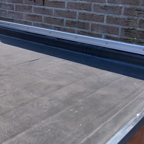 <p>Vliegvuurbestendige ongewapende EPDM folie voor alle daken met uitzondering ongeballast in combinatie met polystyreen isolatie. EPDM LSFR folie is vliegvuurbestendig en zonder open vuur verwerkbaar (verlijming of mechanische bevestiging). De verwerking van EPDM LSFR folie voldoet hierdoor aan de NEN 6050 (Brandveilig detailleren op daken).</p><p><strong>Toepassing</strong></p><p>EPDM LSFR folie wordt toegepast als waterafdichting voor terrasoverkappingen, buitenverblijven, daken, dakkapellen, garagedaken, carports, erkers, aanbouwen enz.</p><p><strong>Verwerking</strong></p><p>• Controleer of de ondergrond vlak en schoon is.<br />• Controleer of ondergrond geschikt is voor de verlijming.<br />• De EPDM folie wordt los op de ondergrond aangebracht.<br />• De folie ca. 20 minuten laten ademen en vervolgens goed leggen.<br />• De EPDM folie voor de helft terug vouwen.<br />• Zowel de ondergrond als de folie volledig voorzien van E225 spraybond.<br />• Wacht tot de lijm droog is.<br />• De folie spanningsloos en plooivrij terugrollen in de aangebrachte lijm en volledig aandrukken middels een grove bezem (advies: vanuit het midden naar buiten vegen).<br />• De EPDM folie langs de dakranden en opstanden altijd volledig (tweezijdig) verlijmen met E225 spraybond.<br />• Altijd kimfixatie toepassen</p><p><strong>Opmerkingen:</strong></p><p>Verlijming is mogelijk op hout, staal, beton, oude bitumineuze dakbedekking (bitumen ouder dan 3 jaar, niet op teerhoudende dakbedekking) en op bitumen gecacheerde isolatieplaten.</p><p><strong>Inhoud pakket:</strong></p><p><br />* EPDM 1,14 mm LSFR.<br />* EPDM contactlijm in blik, hoeveelheid varieert per pakket.<br />* 1 EPDM stadsuitloop 60x80 mm met EPDM slabbe.<br />* 1 koker MS polymeer lijm-kit t.b.v. inwerken doorvoer.<br />* verwerkingsvoorschriften.</p><p>Bij het pakket EPDM Folie word altijd met 20 cm overstek gerekenent.</p>