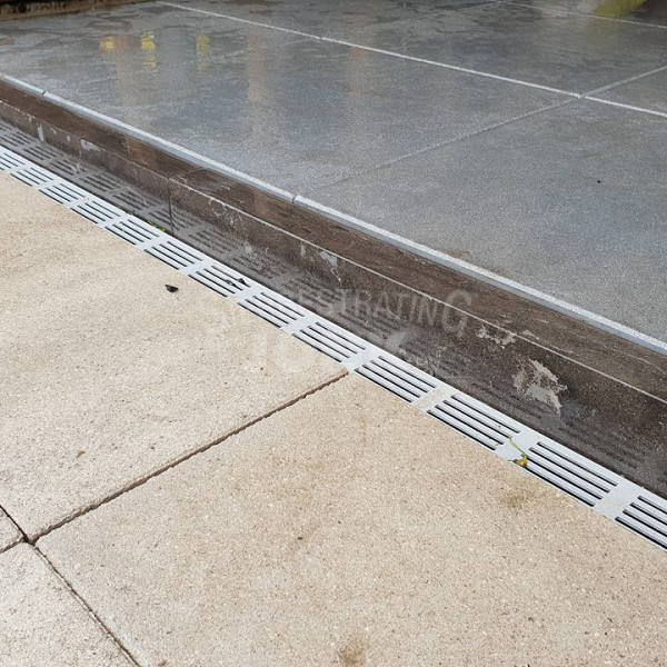 <h1><strong>Aco SlimLine afvoergoten</strong></h1><p>Voor een minimalistische uitstraling van terrassen worden vaak groot formaat tegels gebruikt. Juist bij deze toepassing is de noodzaak voor een goede afwatering extra belangrijk en is een lijnafwateringssysteem (regengoten) de juiste oplossing. De ACO Slimline is een designgoot met een breedte van slechts 6 centimeter. De goot bestaat uit een aluminium design rooster en onderbak uit geëxtrudeerd kunststof. De goot is gemakkelijk te plaatsen en kan worden aangesloten op infiltratievoorzieningen of het riool.</p><p>De Aco Slimline Design goot is een zeer luxe kunststof lijnafwateringsgoot. Het enige wat je er van ziet is het mooie smalle aluminium sleufrooster. De afmeting van de goot is 100x6,1x10,3 cm. Door deze smalle uitvoering is het een mooie goot die wel luxe uitstraalt en heel bescheiden aanwezig is. </p><p>Hulpstukken</p><p>Bij de Aco slimline Design goot zijn vele hulpstukken verkrijgbaar, zoals eindkappen, verloopstukken, verbindingsstukken, onder- en zijafvoeren en een hoekstuk van 90 graden.</p>